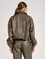 Campera bomber de cuero sintético negra con mangas color beige, cuello clásico y cierre frontal con cremallera.