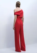 Mono de fiesta rojo con escote bardot y mangas cortas con detalle fruncido. Corte recto, largo y con cierre de cremallera lateral. Incluye forro interior y cintura drapeada.