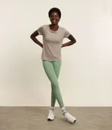 Remera deportiva de manga corta color beige melange, confeccionada en poliamida, con frisos blancos que recorren la espalda y los hombros.