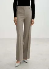 Pantalón de vestir color beige, de corte wide leg, tiro medio y pinzas frontales.