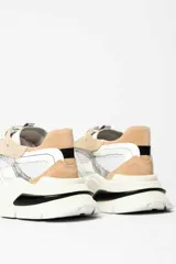Zapatillas deportivas de malla blanca con superposiciones de cuero color beige y verde. Suela gruesa de goma color hueso.