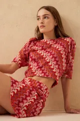 Minifalda de tejido de punto con estampado geométrico en tonos rojo, rosa, naranja y blanco.