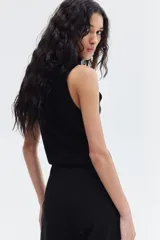 Pantalón cigarette negro de punto elástico pesado con pliegues. Modelo de tiro alto con elástico oculto en la cintura y pinzas adelante y atrás.