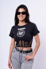 Remera negra de algodón con estampado del logo de la banda de rock Ramones. Presenta un corset de red con cadenas decorativas.