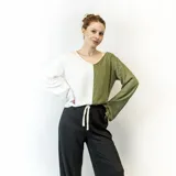 Blusa de mangas largas, con corte holgado y escote redondo. Presenta un diseño color block, con la mitad izquierda en color blanco y la mitad derecha en color verde oliva.