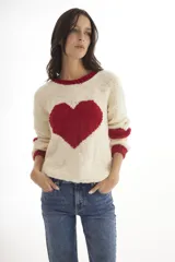 Sweater tejido a mano en Uruguay, color crudo con corazón negro en el frente y detalles en negro en cuello y puños.