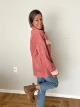 Sobrecamisa de pana texturada color rosa con detalles en tono más claro, corte oversize, bolsillos frontales aplicados y cierre frontal con botones.