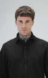 Camisa negra de manga corta con textura floral en relieve y cuello clásico.