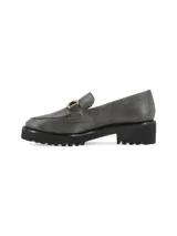 Mocasín gris con detalle de hebilla dorada y suela track negra.