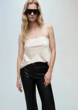Top color crema de tejido fluido y satinado, con tirantes finos, cuello escotado y diseño recto.
