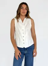 Chaleco beige de lino con escote en V, cierre frontal con botones y terminaciones desflecadas.