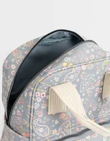Mochila negra de cuerina con doble asa corta de mano con textura, correas regulables, cierre superior, bolsillo frontal con cierre, bolsillos laterales y tag en relieve.