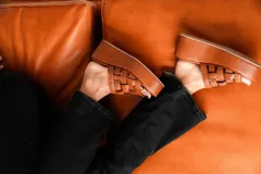 Sandalias negras de cuero con plataforma pareja y tiras de cuero tejidas en la parte superior.