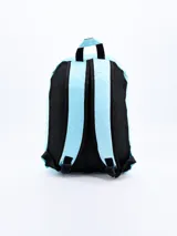 Mochila celeste con ribetes negros, asa superior y correas acolchadas ajustables. Decorada con parches de letras y símbolos en colores brillantes y texturas variadas.