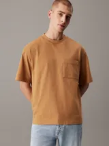 Remera color caramelo de corte holgado, confeccionada en 100% algodón. Tiene mangas cortas, cuello redondo y un bolsillo de parche en el pecho con etiqueta de la marca.