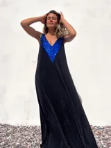 Vestido largo negro de terciopelo con escote en V y apliques de lentejuelas azules en el corpiño.