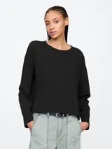 Remera negra de manga larga con cuello redondo y corte holgado.