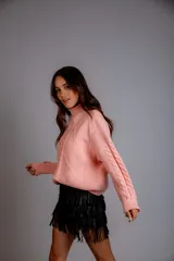 Sweater color crudo con cuello alto y diseño trenzado.