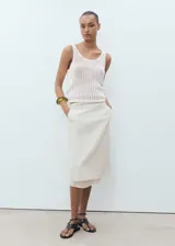 Top blanco de punto calado, sin mangas y con cuello redondo.