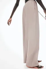 Pantalón largo color topo de punto de algodón, con cintura elástica ajustable con cordón fino. Tiene bolsillos laterales discretos y corte recto.