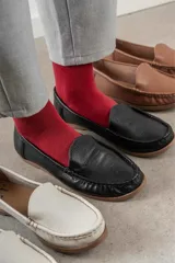 Mocasines de cuero color marrón claro con costuras a la vista.