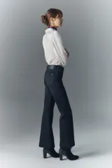Pantalón de jean negro de tiro medio y calce ajustado desde la cintura hasta la rodilla, con pierna acampanada. Confeccionado en tejido confort con elastano, cierre y botón. Forrería estampada con logo de la marca.