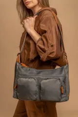 Bandolera de tafeta impermeable, liviana, con dos compartimientos principales, dos bolsillos con cierre y correa regulable con hebilla.