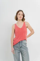 Musculosa tejida color coral con hilo brillante, escote en “V” delantero y trasero y calce relajado.