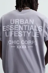 Camiseta gris de corte holgado, cuello redondo y manga corta. Estampado con la frase "Live in Style Everyday" en el frente.