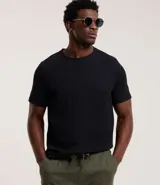 Remera masculina de cuello redondo y manga corta, confeccionada en tejido de media malla con texturas verticales. Corte clásico.