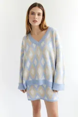 Sweater de lana color beige con diseño geométrico de rombos en tonos beige y blanco, cuello en V y corte holgado.