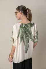 Blusa italiana color natural con estampado de hojas en tonos azules. De calce holgado y talle único.