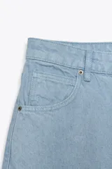 Pantalón de jeans celeste claro, de tiro medio, corte tapered y largo hasta el tobillo. Tiene cinco bolsillos, trabillas en la cintura y cierre frontal con cremallera y botón.