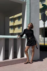 Falda pantalón negra de tiro alto con abertura frontal y cierre lateral con cremallera oculta.