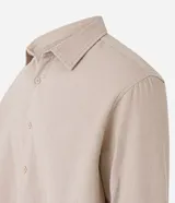 Camisa beige de tricolina texturizada, corte amplio, manga larga y abotonada al frente.