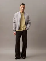 Remera color arena de corte regular, cuello redondo y manga corta. Estampado frontal con el logo de Calvin Klein Jeans en color blanco.