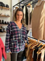 Chaqueta corta con estampado a cuadros azul marino, rosa y blanco. Tiene cuello en V, mangas largas y cierre con lazos.