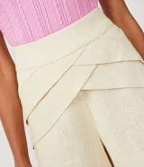 Short color beige confeccionado en viscolino con detalle de pliegues diagonales y cierre de cremallera.