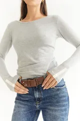 Cinto de cuero color marrón con hebilla metálica y tachas plateadas.