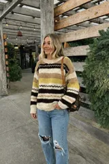 Sweater de lana merino color crema con cuello alto y diseño con motivos geométricos en amarillo, naranja, violeta y negro.