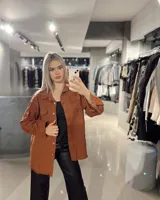 Sobrecamisa color marrón con cuello camisero, cierre frontal con botones, mangas largas con puños abotonados, dos bolsillos de parche en el pecho y ruedo desflecado.