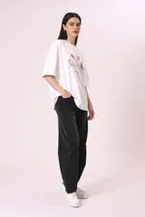 Remera negra de corte oversize con estampado abstracto en tonos rojos, grises y blancos.