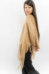 Poncho tejido color cobre con apliques de piedras y flecos.
