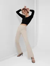 Pantalón tipo calza color beige, de corte flare y tiro alto.