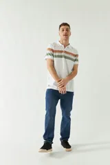Pantalón de jean azul oscuro, corte slim, tiro medio, con bolsillos delanteros y traseros, y cierre con cremallera y botón.