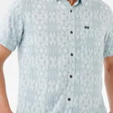 Camisa celeste con estampado geométrico en blanco, de manga corta, con cuello abotonado y bolsillo en el pecho.