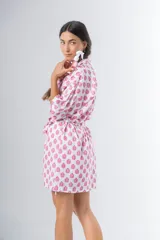 Bata kimono corta de algodón estampado con flores rojas, violetas y verdes. Tiene mangas al codo y lazo de ajuste en la cintura.