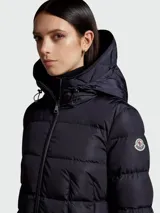 Campera larga impermeable color azul con capucha integrada y relleno de plumas, diseño elegante.