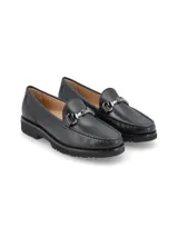 Mocasín de cuero negro con detalle de hebilla metálica plateada.