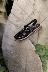 Sandalias de cuero marrón con tiras entrecruzadas y hebilla dorada al tobillo.